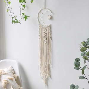 Detailed macro view of macrame moon dream catcher with wooden owl charm and tassels
