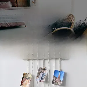 Detail of woven cotton macrame photo holder with wooden clips and natural rod