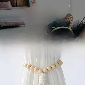 Close-up of Nordic style curtain tieback with natural wood beads and cotton tassel detail