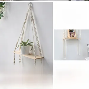 Detail of bohemian hand-woven cotton rope wall shelf with light natural wood board