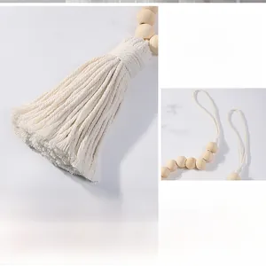 Detail of wooden bead curtain tieback with white cotton tassel in boho style