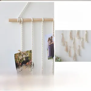 Detailed view of hand-woven macrame wall hanging with wooden photo clips and tassels