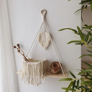 Close-up of bohemian hand-woven cotton leaf and fringe shelf for wall decor