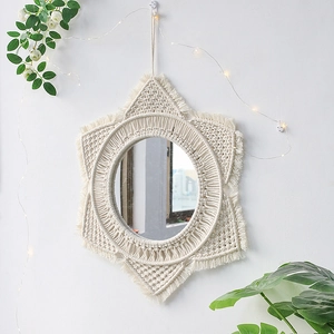 Detalle de espejo de pared bohemio tejido a mano con flecos de macramé y forma de estrella