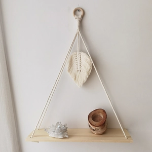Detail view of woven cotton rope leaf decoration and wooden shelf for wall storage