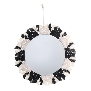 Detailed macro view of bohemian macramé woven fringe on a round black and white wall mirror