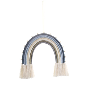 Detail view of woven rainbow wall hanging with white pom poms and cream cotton tassels