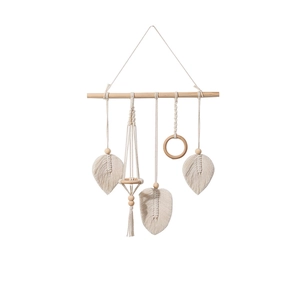 Detail of bohemian hand-woven cotton macrame wall hanging with leaf shapes and wood beads