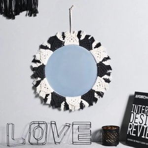 Detailed view of handmade black and white macrame fringe around a bohemian wall mirror