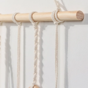 Close-up detail of bohemian handmade woven cotton rope textures on a natural wood bar