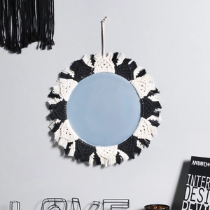 Close-up of handmade black and white macrame cotton fringe on the round wall mirror decor