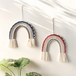 Detail of handmade woven rainbow wall hanging with cotton tassels and wooden beads decor