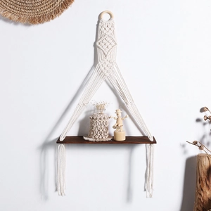 Detail of bohemian handmade woven cotton rope wall shelf with solid wood board