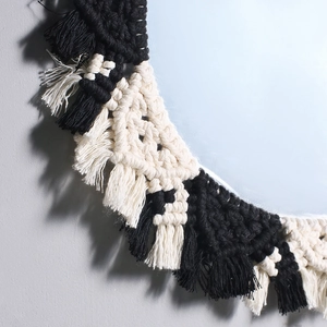 Close-up of bohemian woven cotton rope mirror frame with intricate black and white patterns