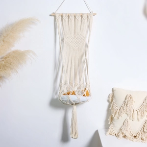 Detail of bohemian handmade woven cat hammock with heart pattern and white cotton tassels