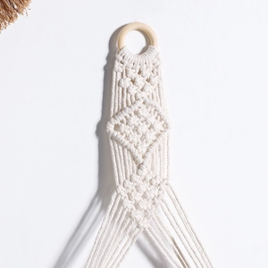 Detailed macro view of bohemian hand-woven cotton macrame with a natural wooden ring