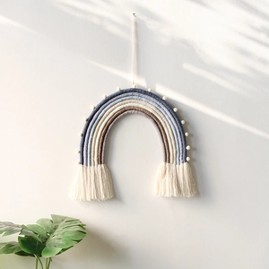 Handmade woven rainbow wall hanging with soft pom-poms for Nordic home nursery decor