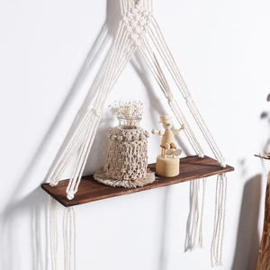 Macro view of a bohemian wall shelf with woven cotton rope and dark wood grain texture