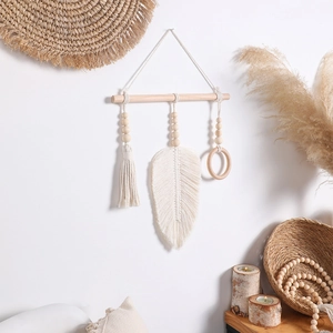 Close-up of handmade bohemian woven wall hanging with cotton tassels and wooden beads