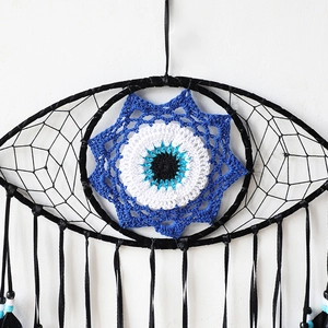 Detail of bohemian evil eye dream catcher featuring black crochet and blue beads