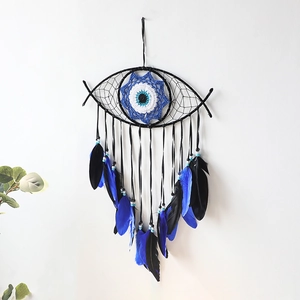 Detail of blue evil eye dreamcatcher with woven eye pattern and soft feathers