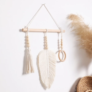 Detail showing handcrafted macrame bohemian wall hanging with cotton feathers and wood beads