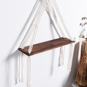 Handmade boho macrame wall hanging shelf with dark wood board and cotton fringe tassels
