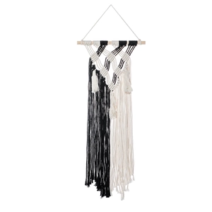 Detail of bohemian hand-woven wall hanging with black and white cotton fringe and wood rod