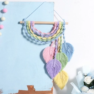 Detail of macaron leaf macrame wall hanging with pastel cotton ropes and wooden rod