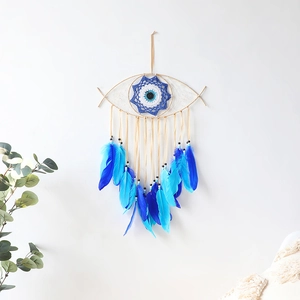 Macro view of blue feathers and beads on evil eye dream catcher wall hanging decor