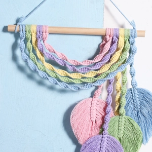 Bohemian woven wall hanging with colorful leaf tassels on a wooden rod for home decor