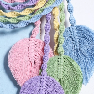 Detail of colorful macrame wall hanging showing intricate leaf-shaped tassels and texture