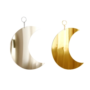 Detail of hanging crescent moon mirrors in gold and silver finish with chains