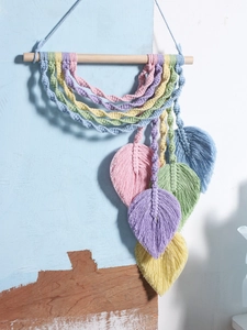 Detailed close-up of handmade woven macrame leaf wall hanging with colorful cotton tassels