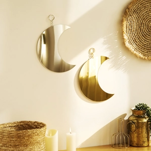 Detail of bohemian gold and silver crescent moon mirrors hanging on a beige wall decoration