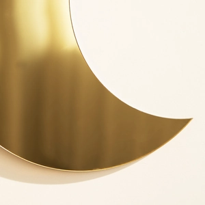Close-up of golden crescent moon wall decor with high-gloss mirror surface finish
