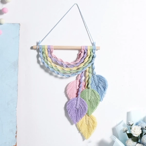 Handmade macrame wall hanging with pastel leaf tassels on wooden rod for home decor