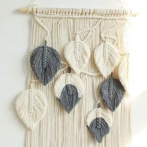 Handmade boho macrame wall hanging with woven feathers and natural wood branch