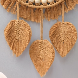 Detail of hand-woven bohemian leaf pattern wall hanging with cotton rope and wood beads