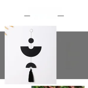 Detailed view of modern black geometric wall decor with wood discs and elegant long tassels