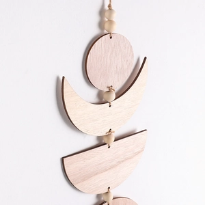 Detail of wooden moon phase wall hanging showing natural wood grain and laser-cut edges