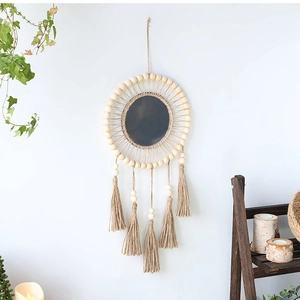 Detail of bohemian macrame wall mirror with decorative wooden beads and handmade tassels