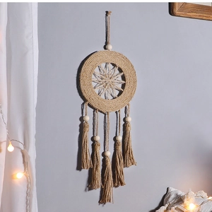 Detail of bohemian woven dream catcher with star pattern, wood beads and jute tassels