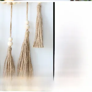 Macro detail of handmade macrame wall mirror with beige cotton fringe and wood beads