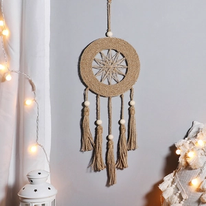 Close-up of handmade macrame dream catcher with wooden beads and tassels on a wall