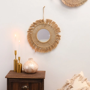 Detail of bohemian woven macrame wall mirror with beige tassels for home decor