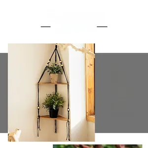 Detail of a 2-tier macrame corner wall shelf made with light wood and black cotton ropes