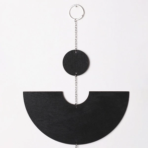 Minimalist matte black geometric wood wall hanging with silver metal chains and tassels