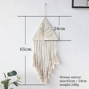 Dettaglio decorazione da parete boho tessuta a mano con nappe e nodi in macramè