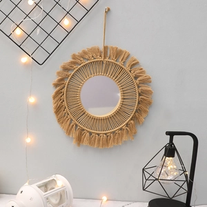 Close-up of handmade Bohemian macrame wall mirror with beige cotton fringe detail